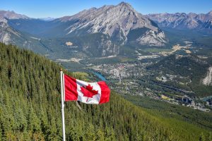 Canada flag with Canadian rocky mountain at the background